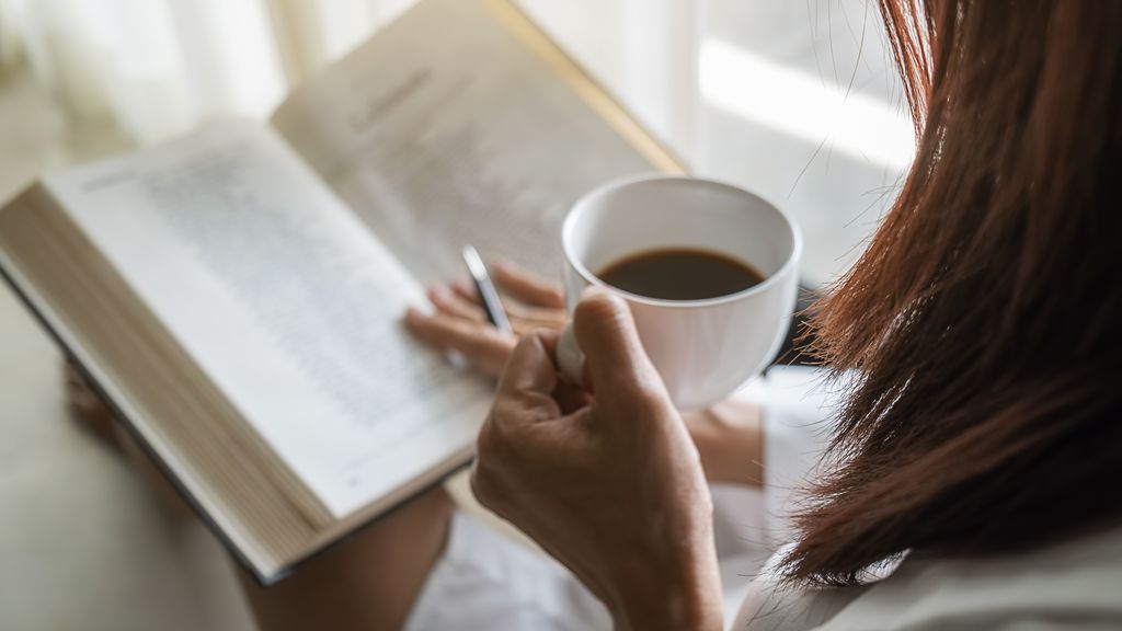 woman drinking coffee and reading book 