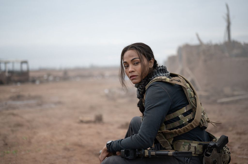Zoe Saldana in military gear on a battlefield