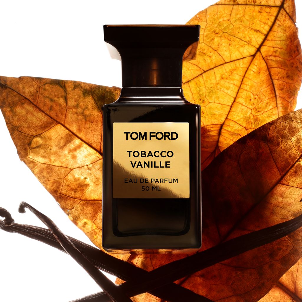 A bottle of Tom Ford's Tobacco Vaniile with autumnal leaves and vanilla pods