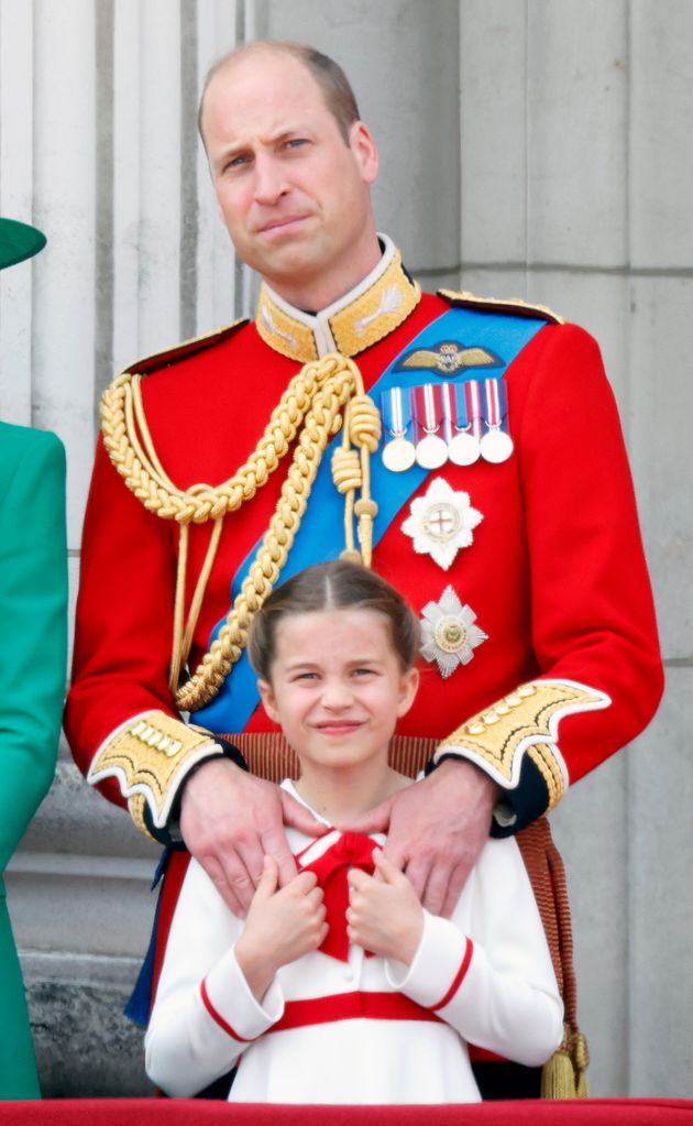 Princess Charlotte and Prince William holding hands on the balcony of Buckingham Palace 