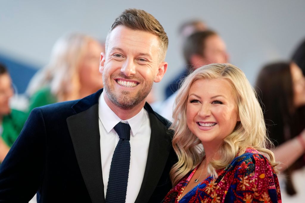 chris and rosie ramsey posing on red carpet smiling 