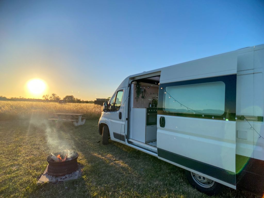 campervan in a field with the sun setting