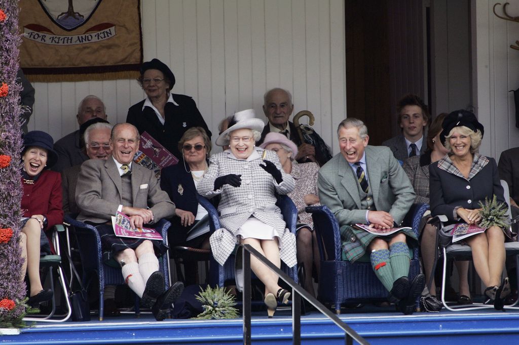 Then-Prince Charles, Prince of Wales and Camilla, Duchess of Cornwall with Queen Elizabeth II and Prince Philip, Duke of Edinburgh laugh at their Balmoral team in the tug of war competition at  the Braemar Games Highland gathering on September 2, 2006, Scotland 
