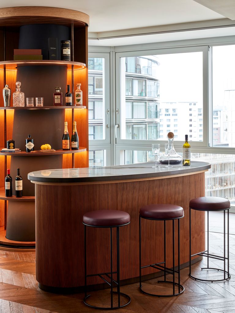 Illuminated bar with bar stools and floor-to-ceiling windows