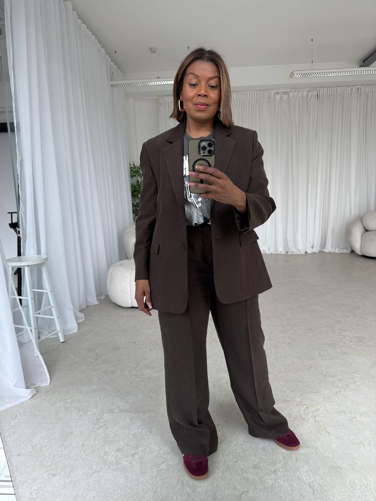 woman taking a selfie in  a brown suit 