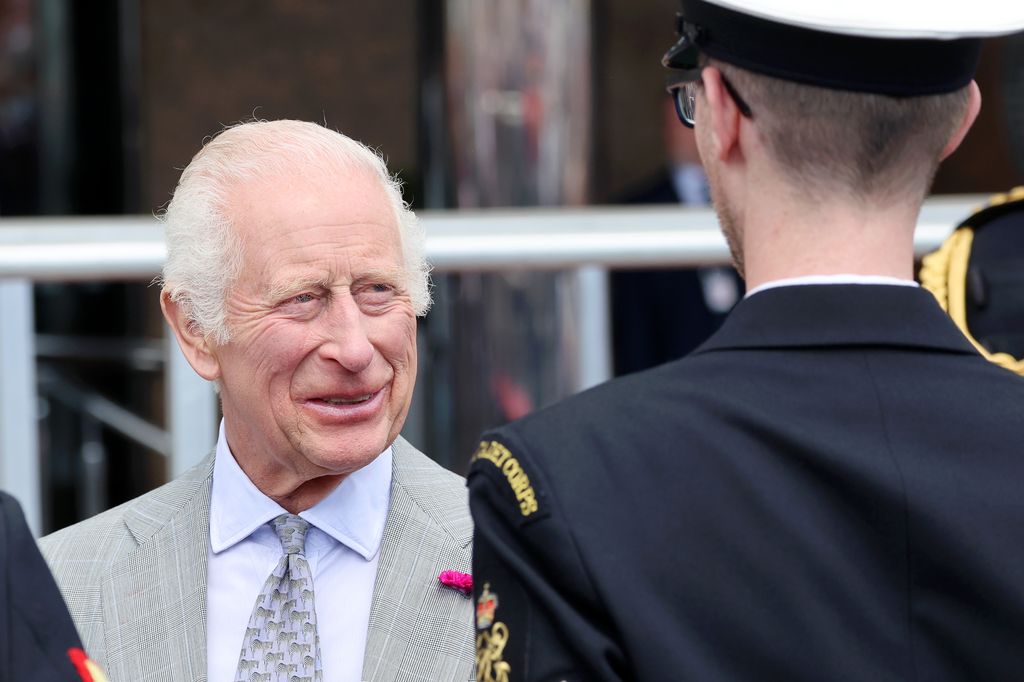 king charles smiling in grey suit