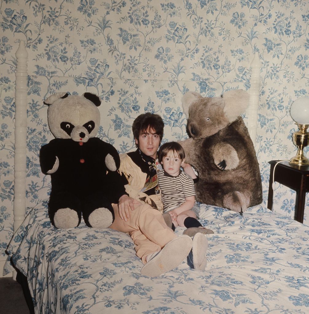 Man and boy in bedroom with two large stuffed animals