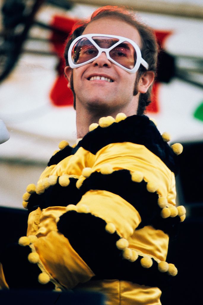 elton john in striped top playing piano