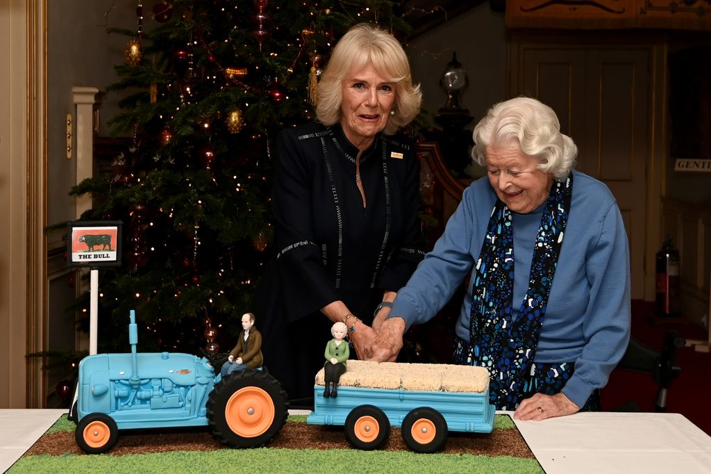 Camilla, Duchess of Cornwall and June Spencer cut an Archers themed cake during a celebration of "The Archers" 70th anniversary at Clarence House 