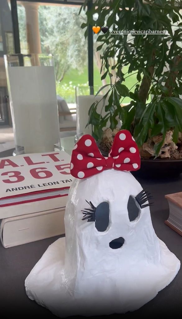 A decorative ghost with fake eyelashes and a Minnie Mouse bow