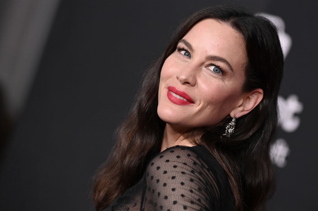 Liv Tyler porte un haut en maille noire à pois.
