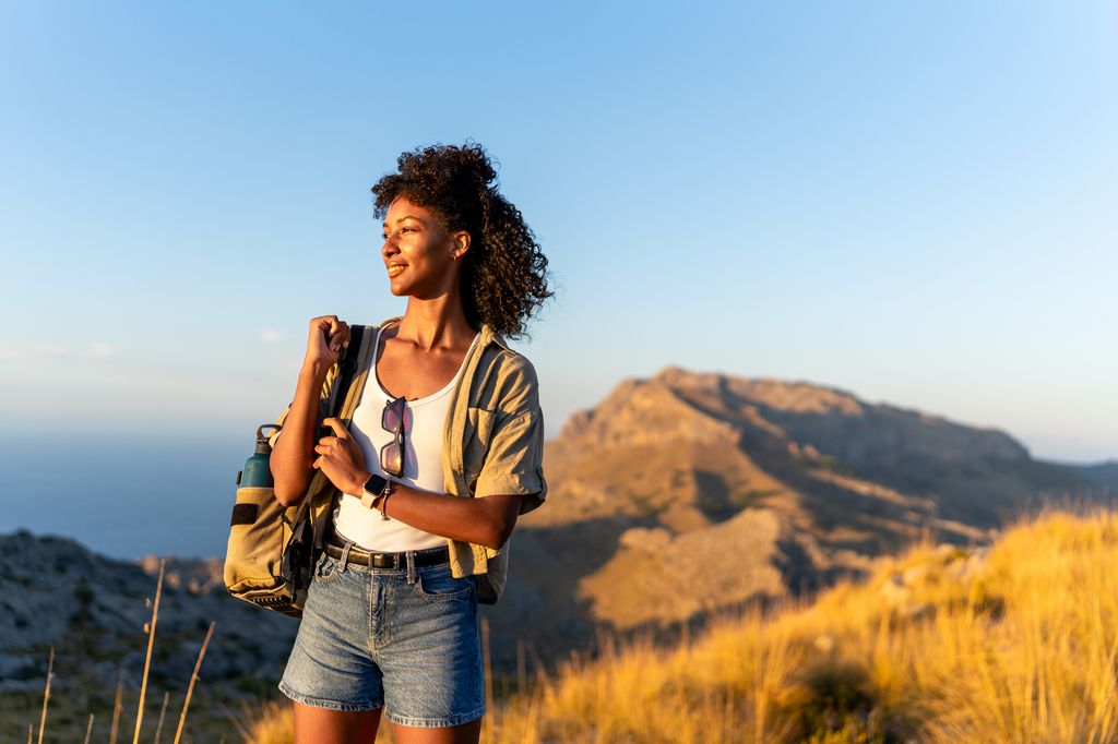 Smiling hiker woman enjoying sunset in the Majorca mountains