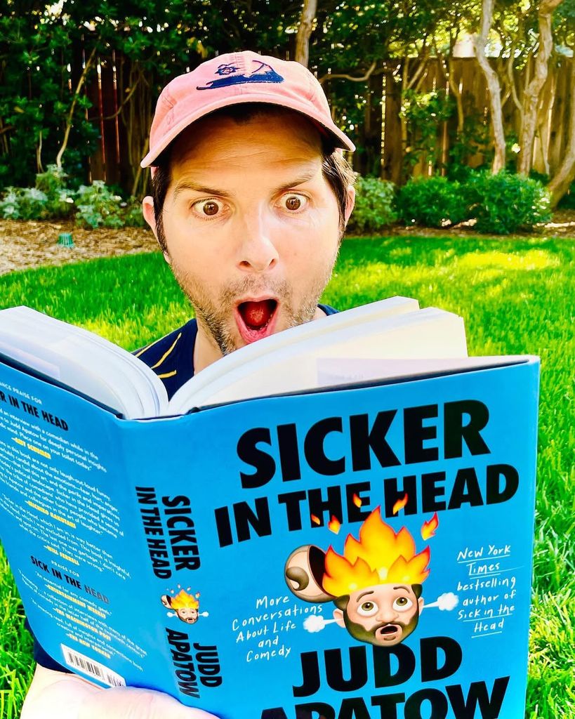 Adam Scott reading a book in his garden