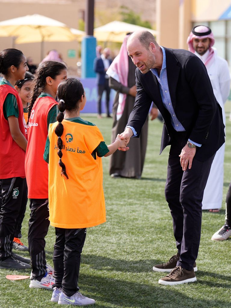 The Prince of Wales speaks with a group of young female footballers during a visit to MISK Sports City in Riyadh