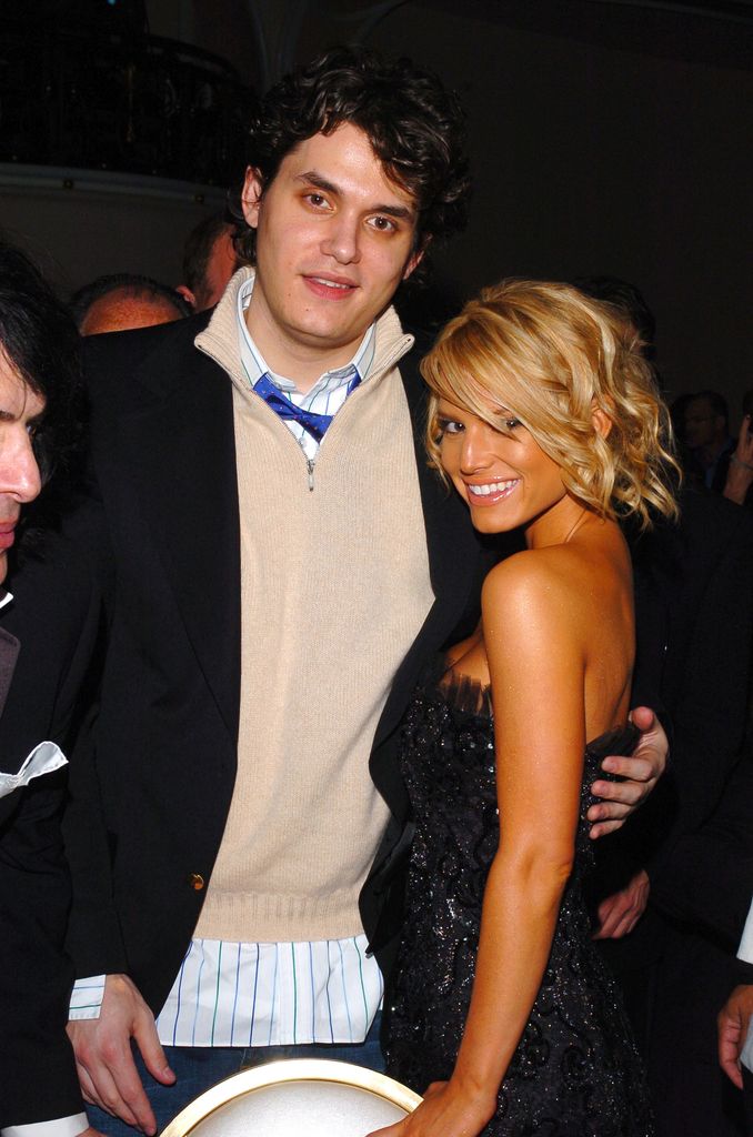 John Mayer in black blazer and cream sweater and Jessica Simpson in black dress