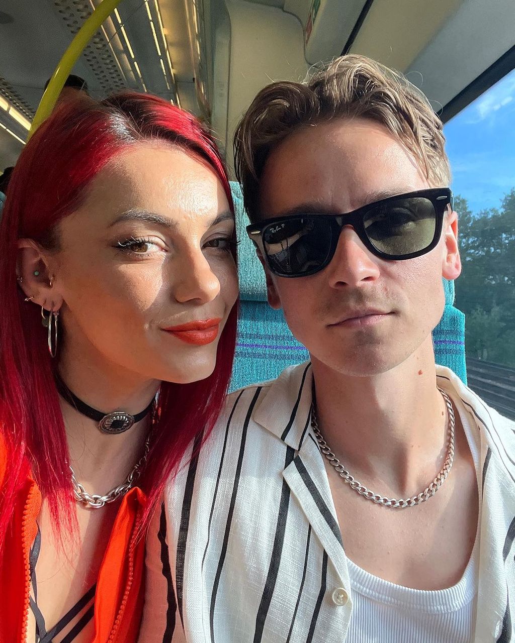 Dianne Buswell and Joe Sugg posing for a selfie in a train