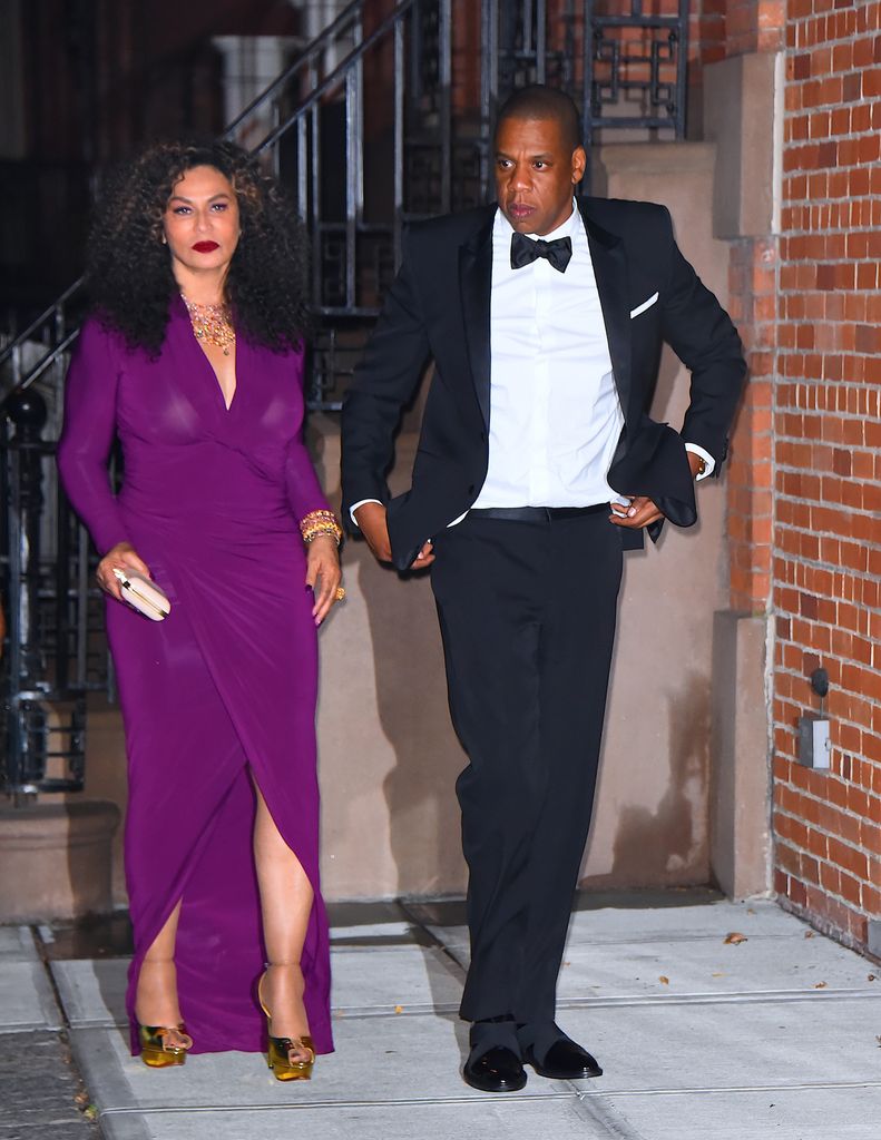 Tina Knowles in a purple dress walking with Jay-Z in a tuxedo