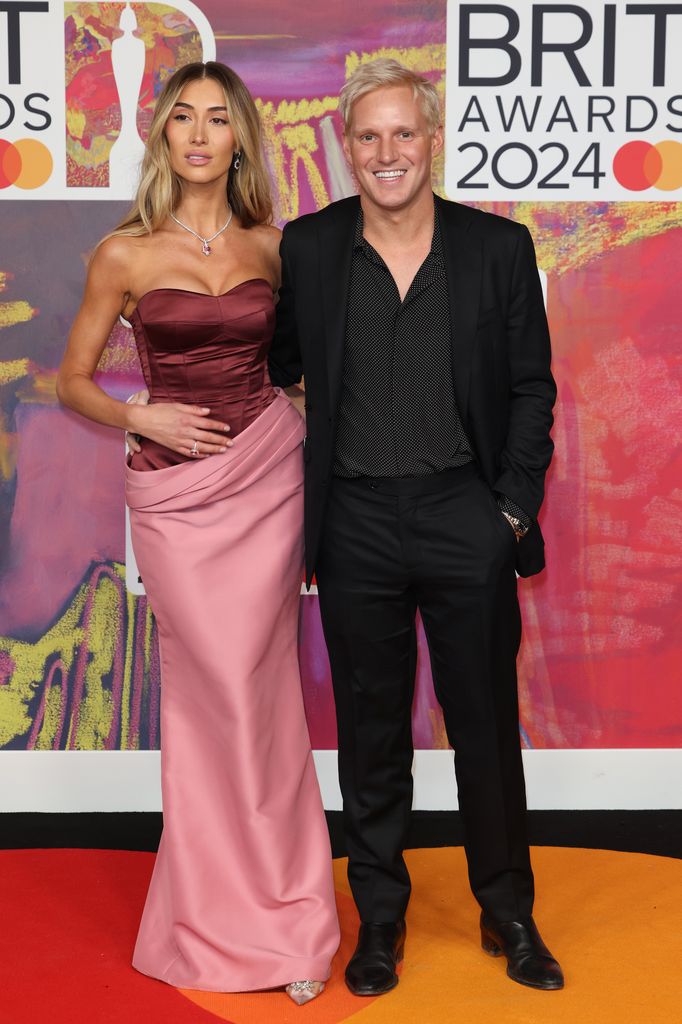 Sophie Habboo and jamie laing in front of BRITS sign on the red carpet