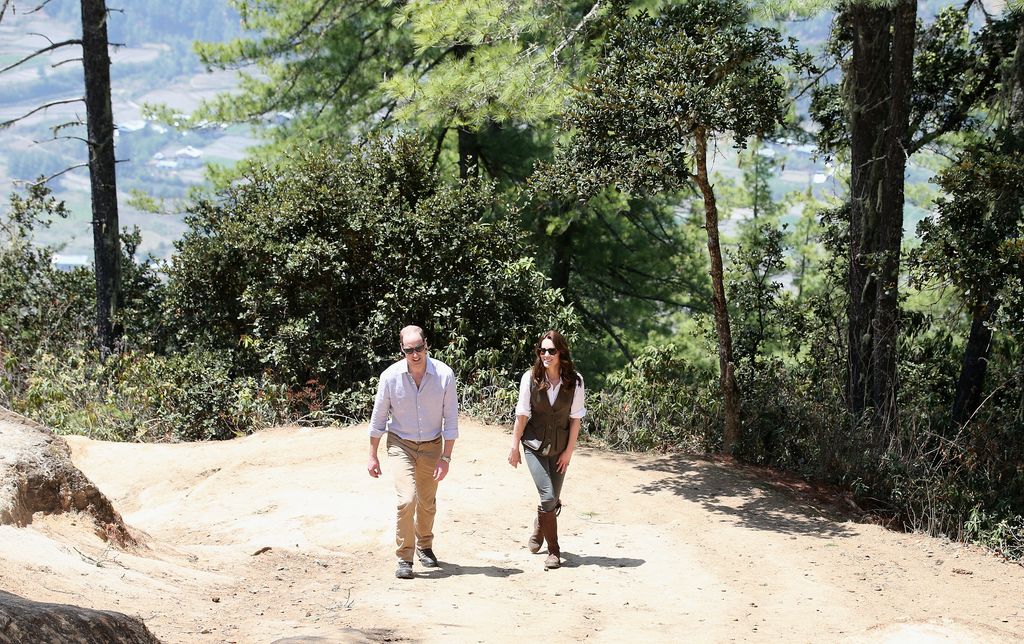 Prince William and Princess Visit India and Bhutan walking up a mountain in outdoors clothes