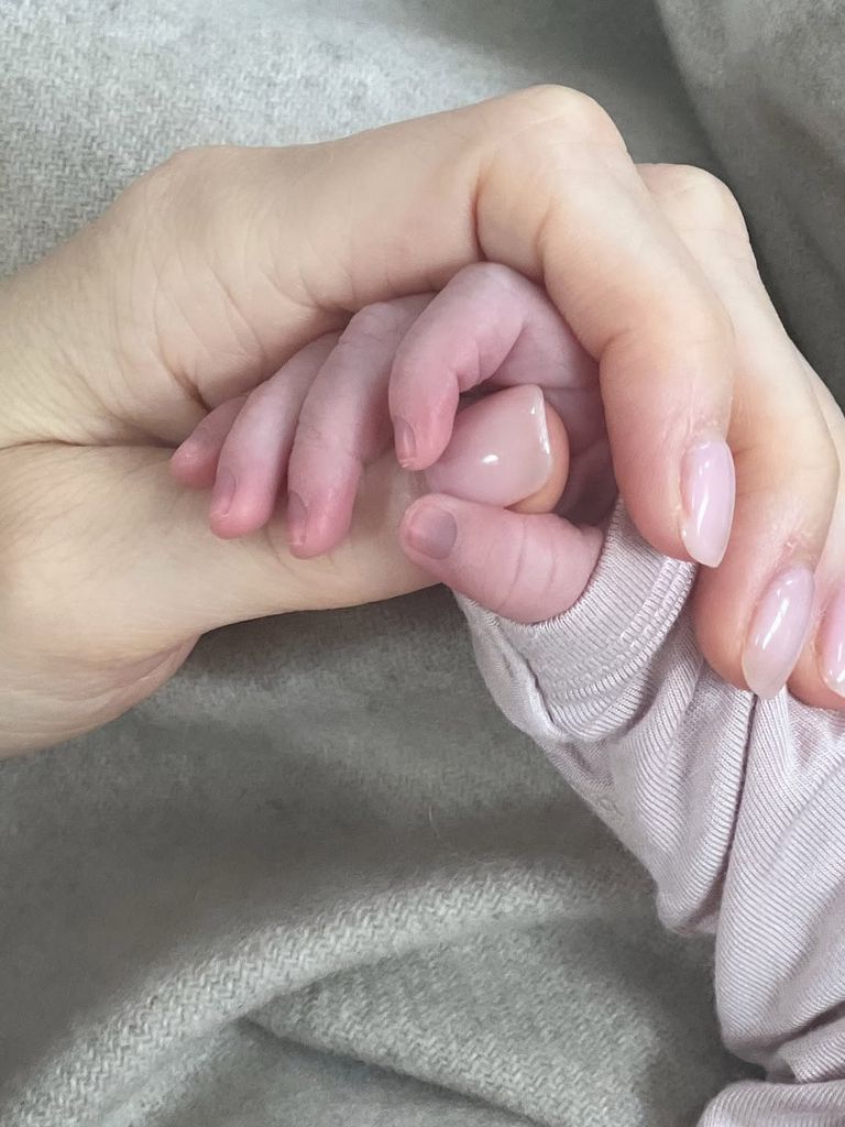 Cassidy Gifford holds her newborn daughter's hand