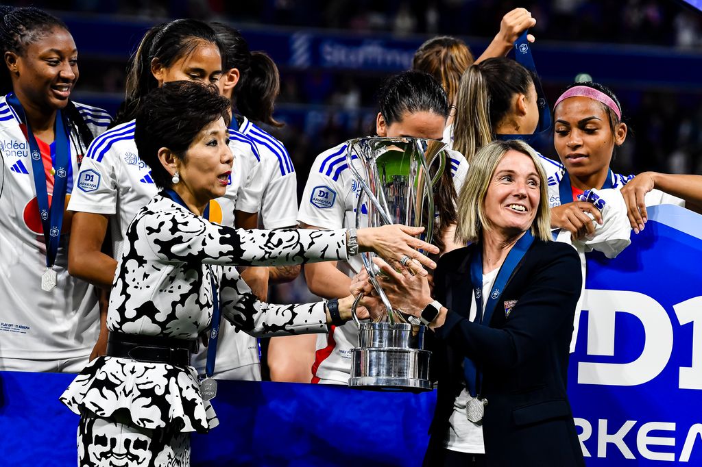 Olympique Lyon Women's team owner Yongmee Michele Kang (L) passes the winners trophy for Olympique Lyon Head Coach Sonia Bompastor (R) 