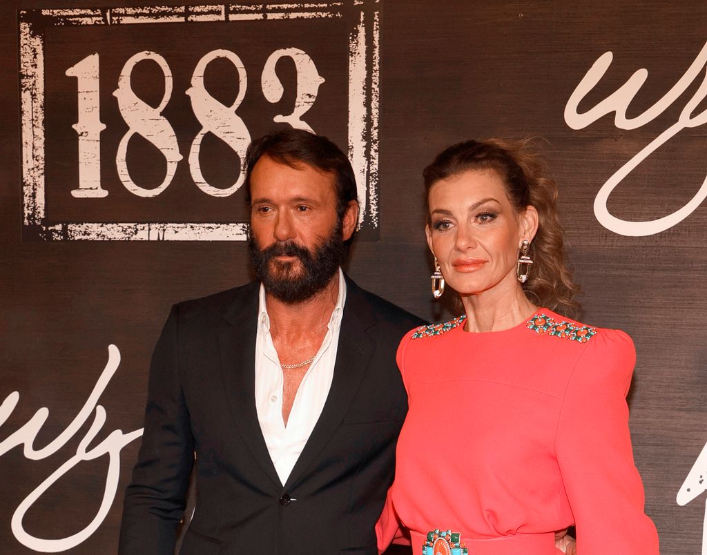 Tim with big beard and head of hair with Faith wearing an orange dress