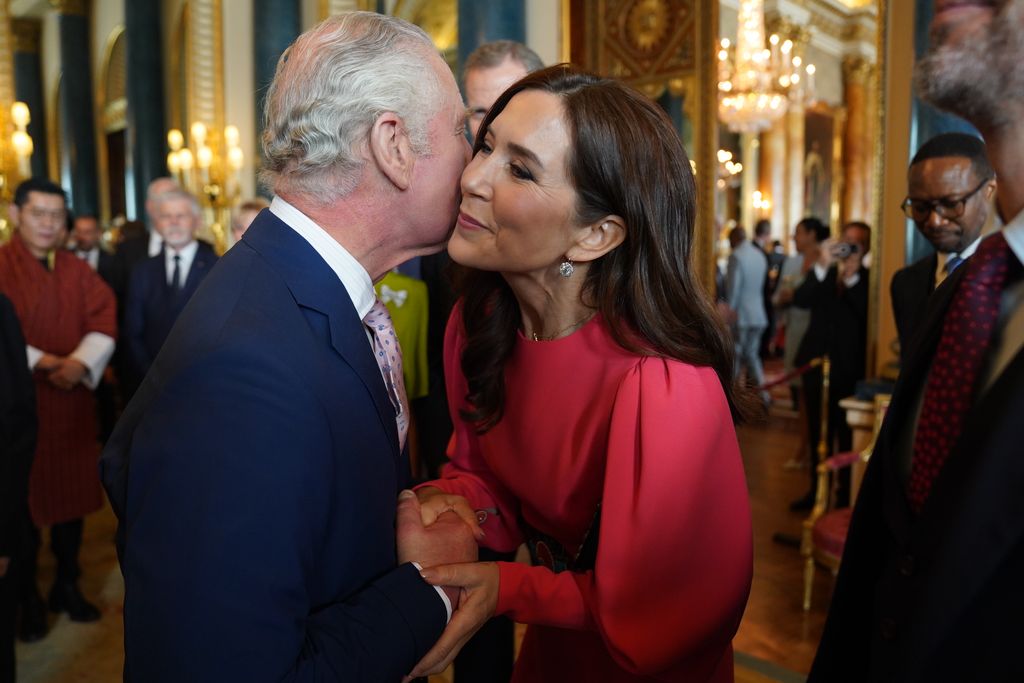 King Charles kissing Princess Mary of Denmark in the cheek
