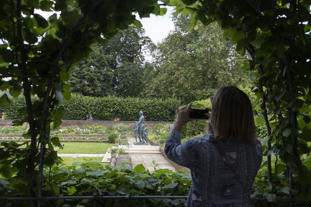 lady taking photo of diana statue