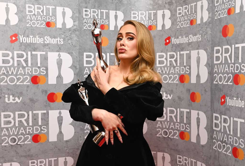 Adele in black dress holding award
