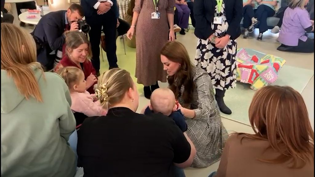 Kate talking with a young girl and her baby brother 