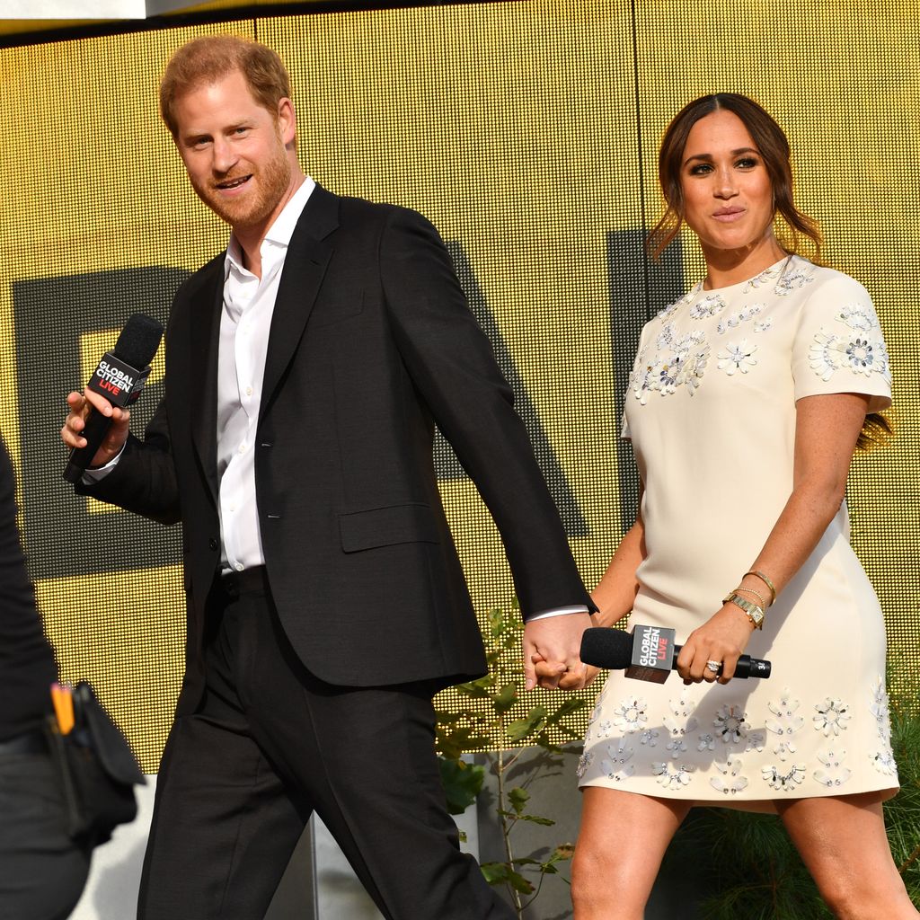 Prince Harry and Meghan Markle walking with microphones