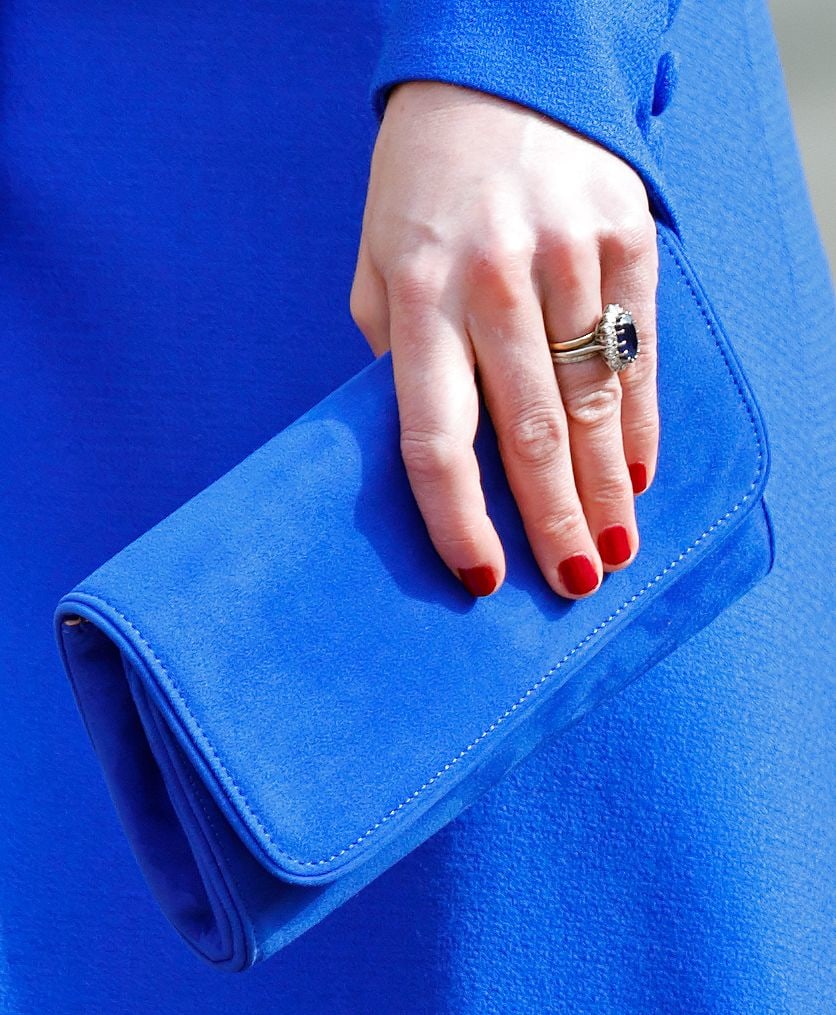 Kate's red manicure holding blue clutch