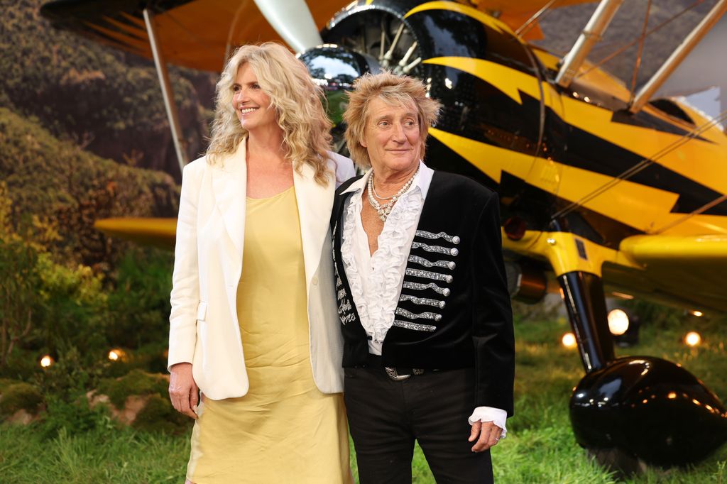 woman in yellow dress and man in ruffle shirt and black jacket 