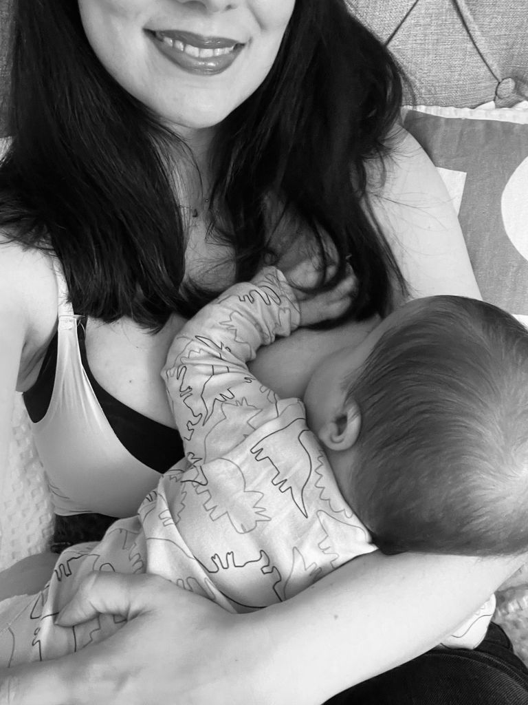 Smiling woman with breastfeeding baby 