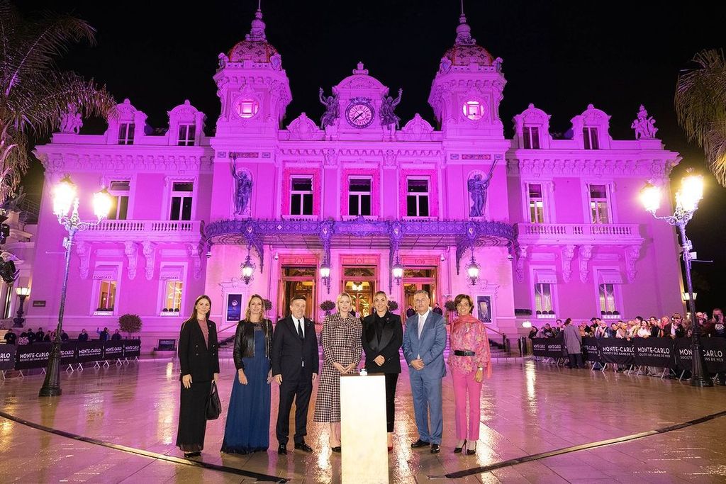 Princesa Charlene em frente à Praça do Cassino de Mônaco, iluminada em rosa