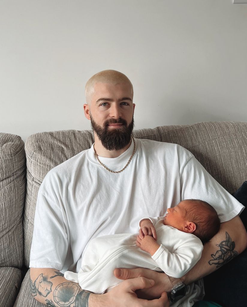 uncle holding baby boy on sofa