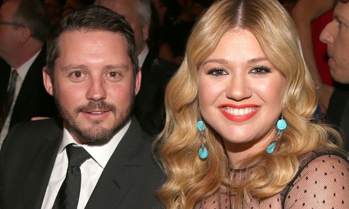 Kelly Clarkson smiles as she joins a smartly-dressed Brandon Blackstock