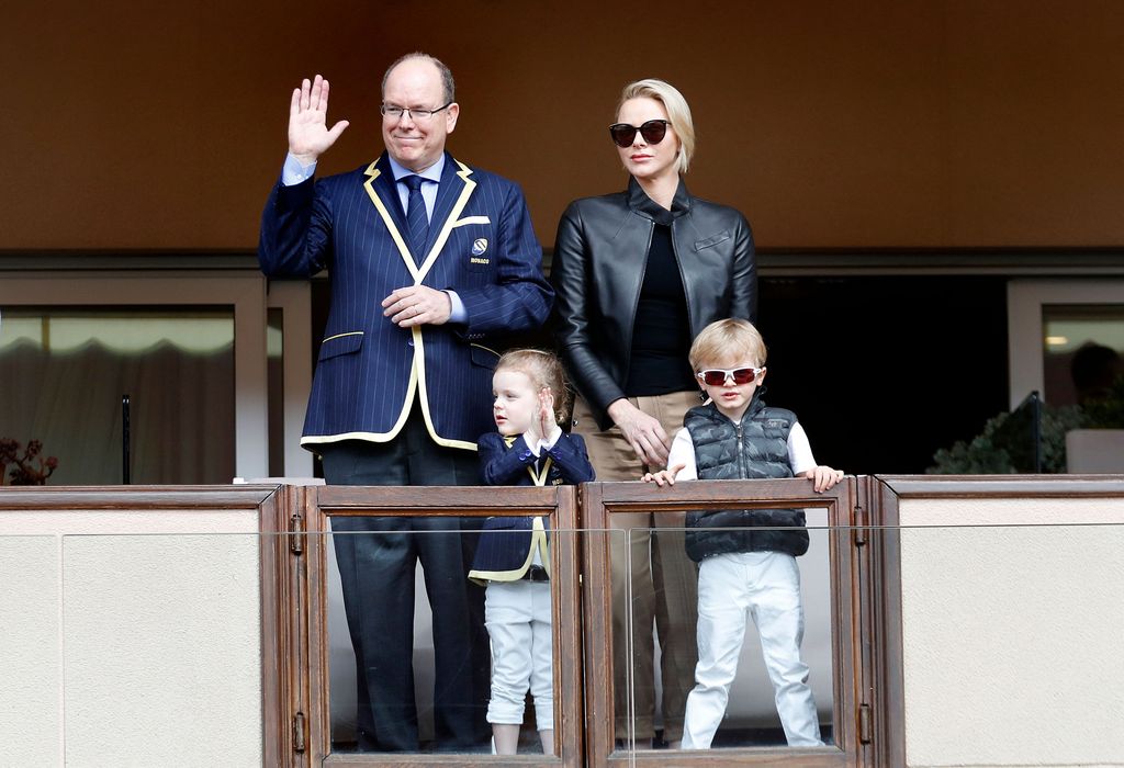 Princesa Charlene de óculos escuros com o marido Albert acenando e seus dois filhos
