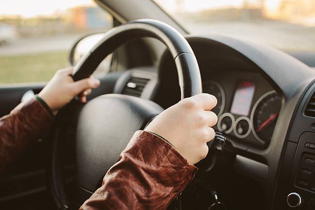 man holding steering wheel driving