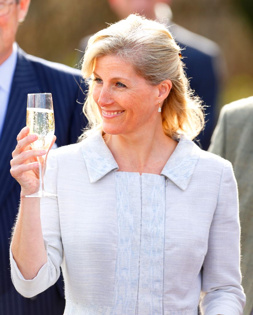 Duchess of Edinburgh holding a glass of sparkling wine at vineyard