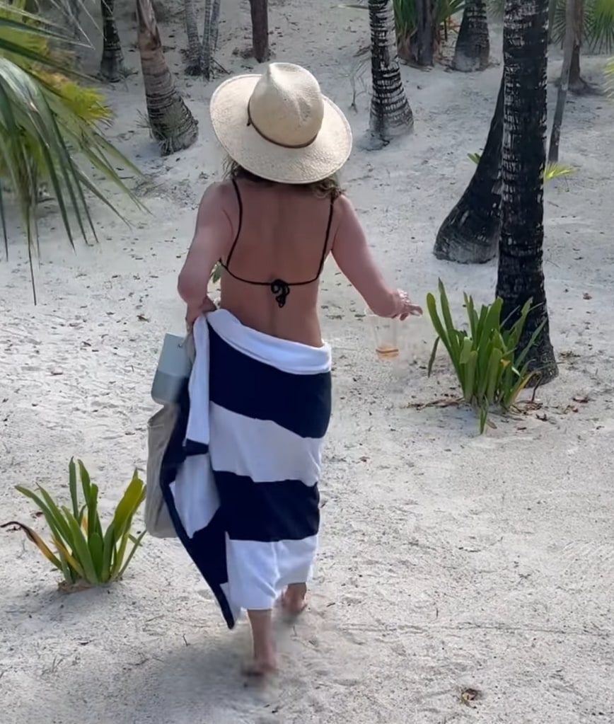 Still from a video shared by Jennifer Aniston on Instagram September 2023 where she is pictured in a black bikini walking around the beach during a vacation with Jimmy Kimmel, Molly McNearney, Jason Bateman, Amanda Anka, and Will Speck