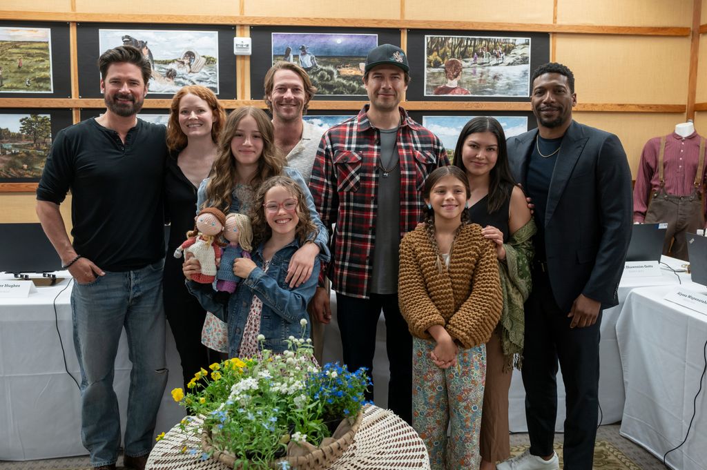 group of actors posing for photo at table read