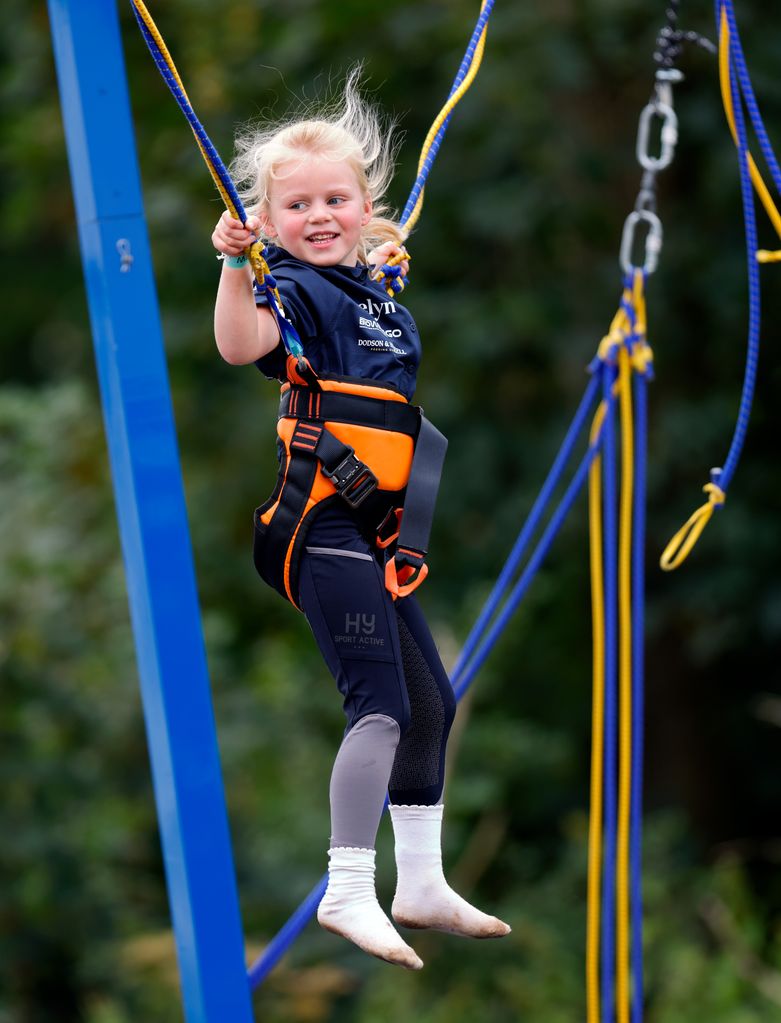 Lena Tindall plays on a bungee trampoline as she attends day 1 of the 2023 Festival of British Eventing at Gatcombe Park