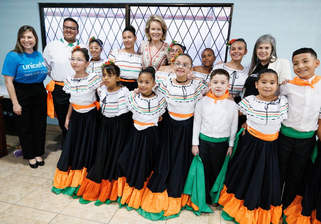 Queen Mathilde standing with a group of children