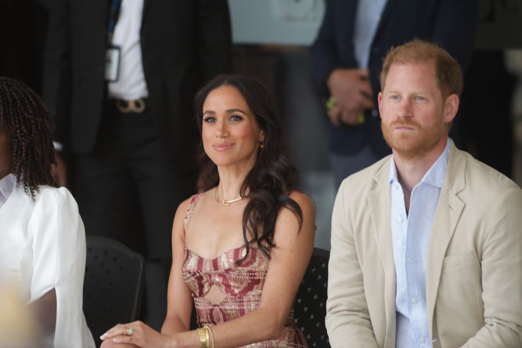 Pangeran Harry dan Meghan Markle duduk dengan tangan di atas lutut