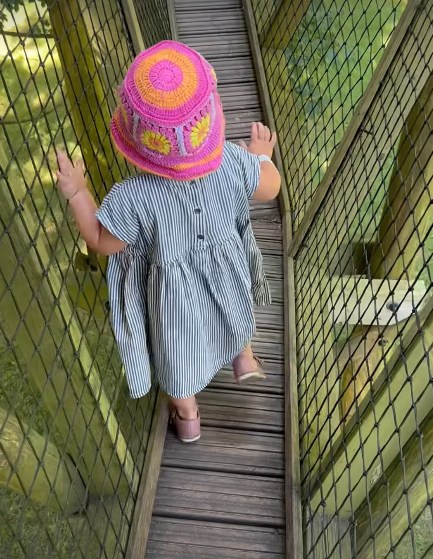 Photo of a little girl walking along a bridge