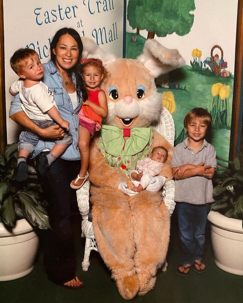 Joanna holding two children in her arms stood next to a person in an Easter Bunny costume who is sat next to Drake, and holding a baby Emmie
