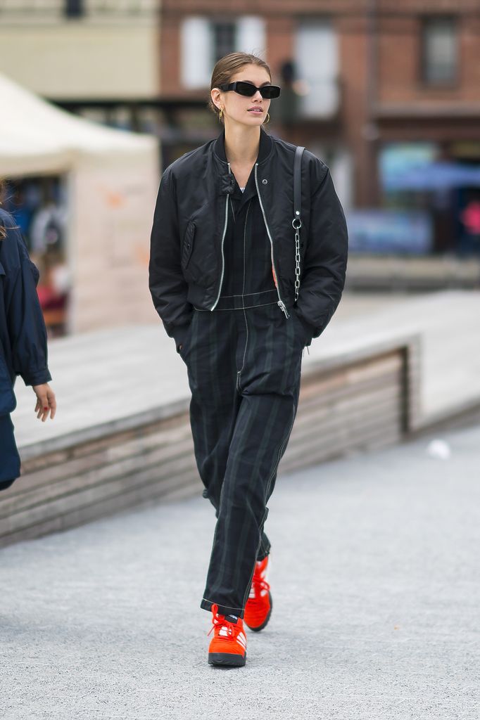 kaia gerber in a black bomber jacket