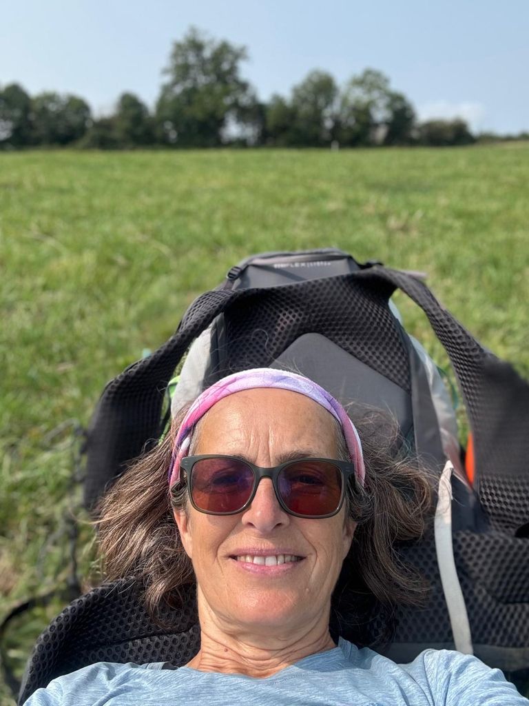 Woman lying down on a backpack in the sun 