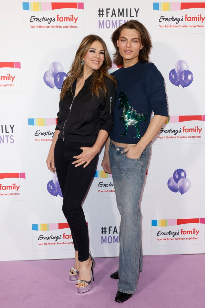 mother and son posing on purple carpet 